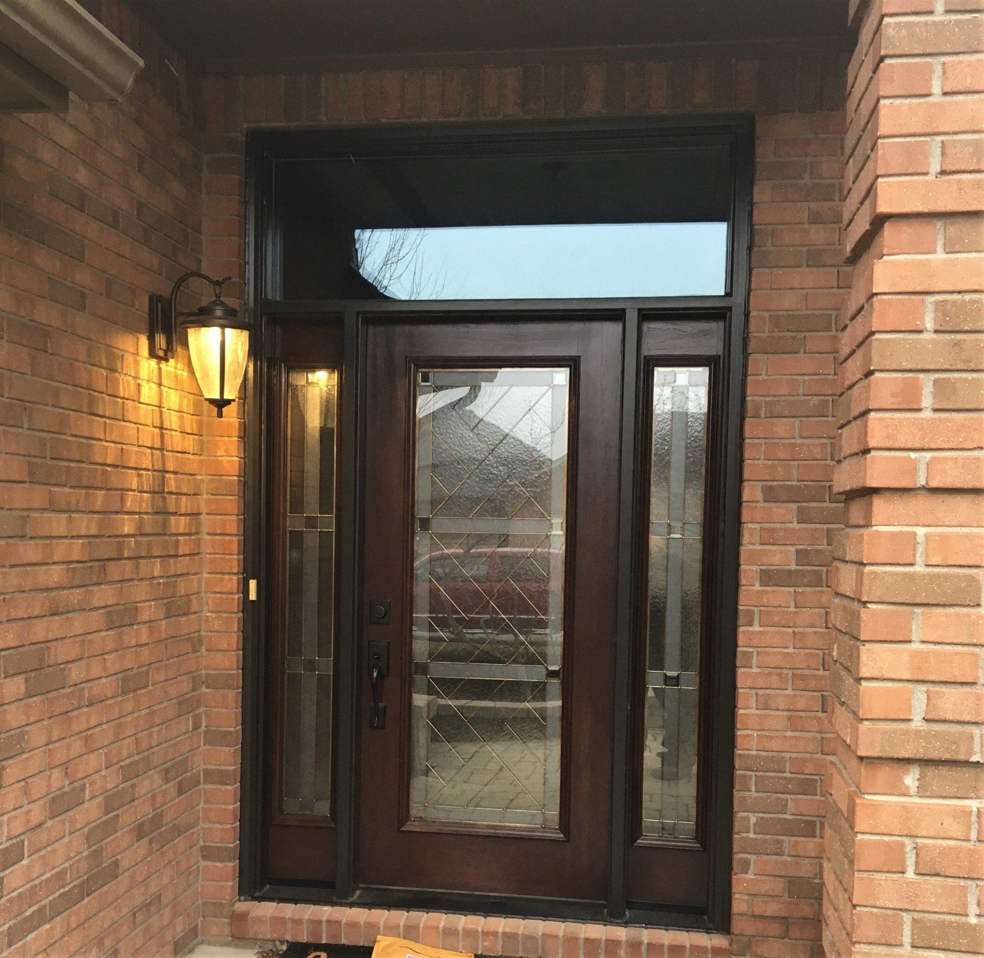 The front door of a brick house with a wooden door
