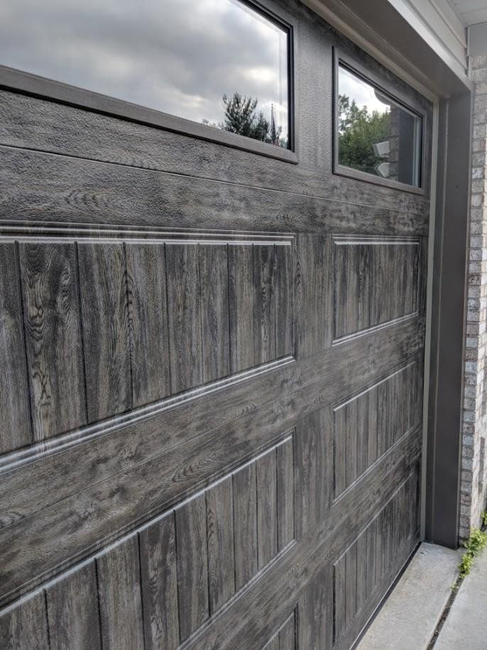 A close up of a wooden garage door with a window.