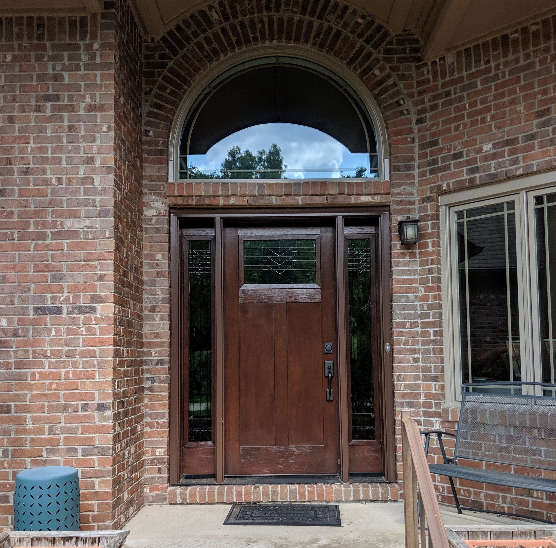 The front door of a brick house with a wooden door