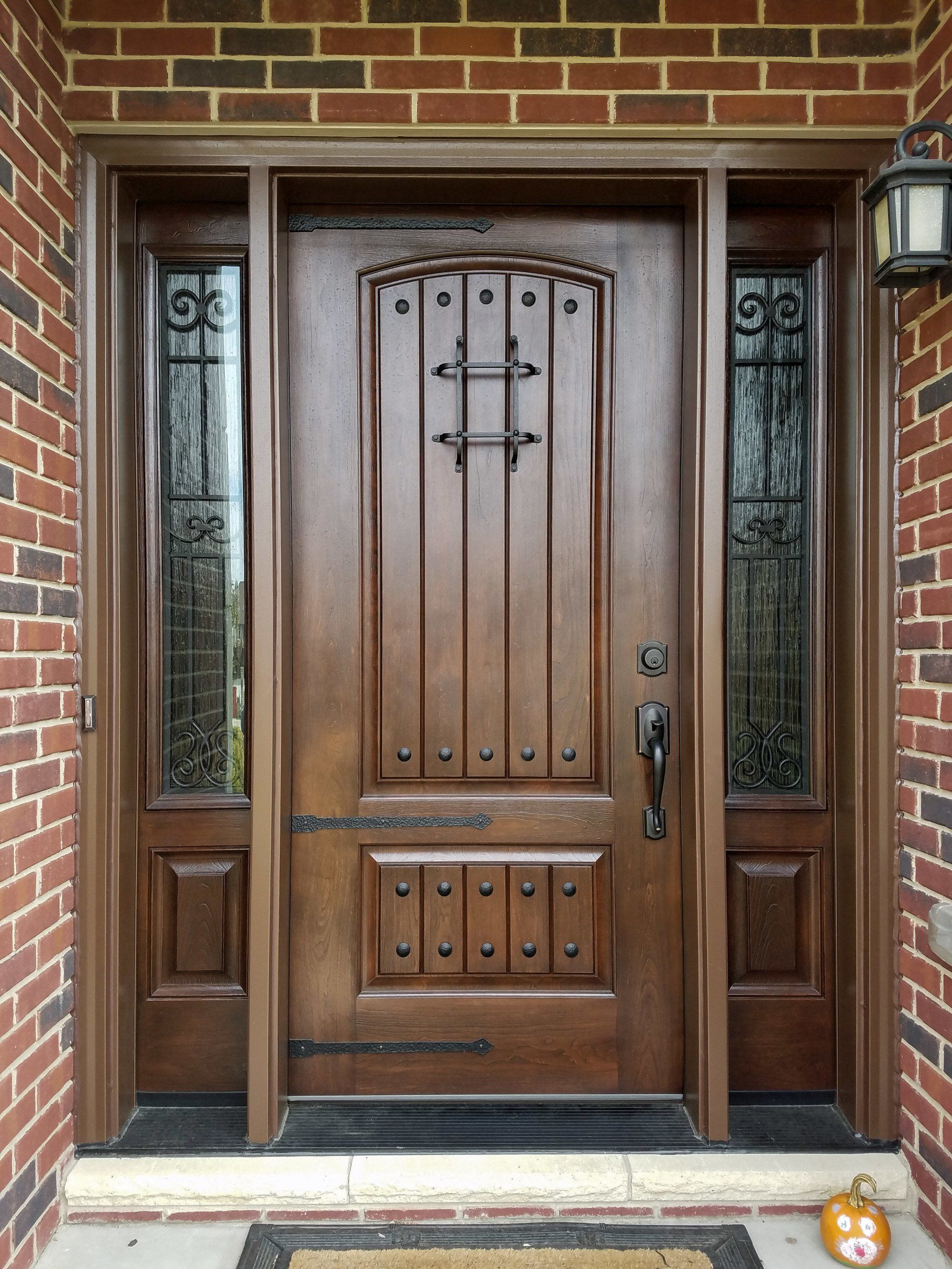 A wooden door with a brick wall behind it