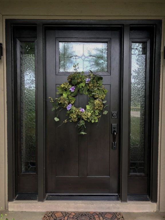 A wreath is hanging on the front door of a house.