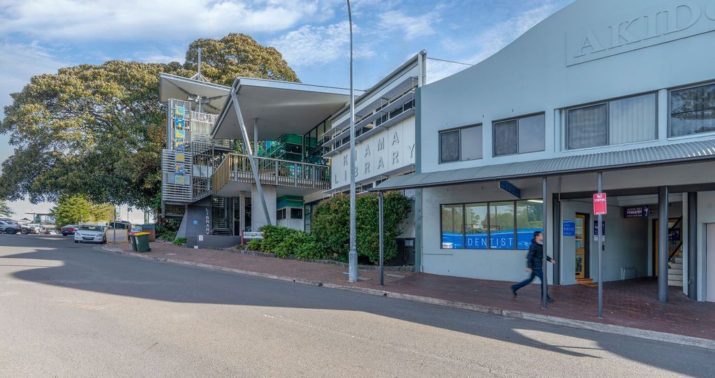 Street View With Two Buildings; Person Walking; Tree in Background — Dr John Salmon, Kiama Family Dental In Kiama, NSW