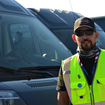 amazon delivery driver posing in front of van 