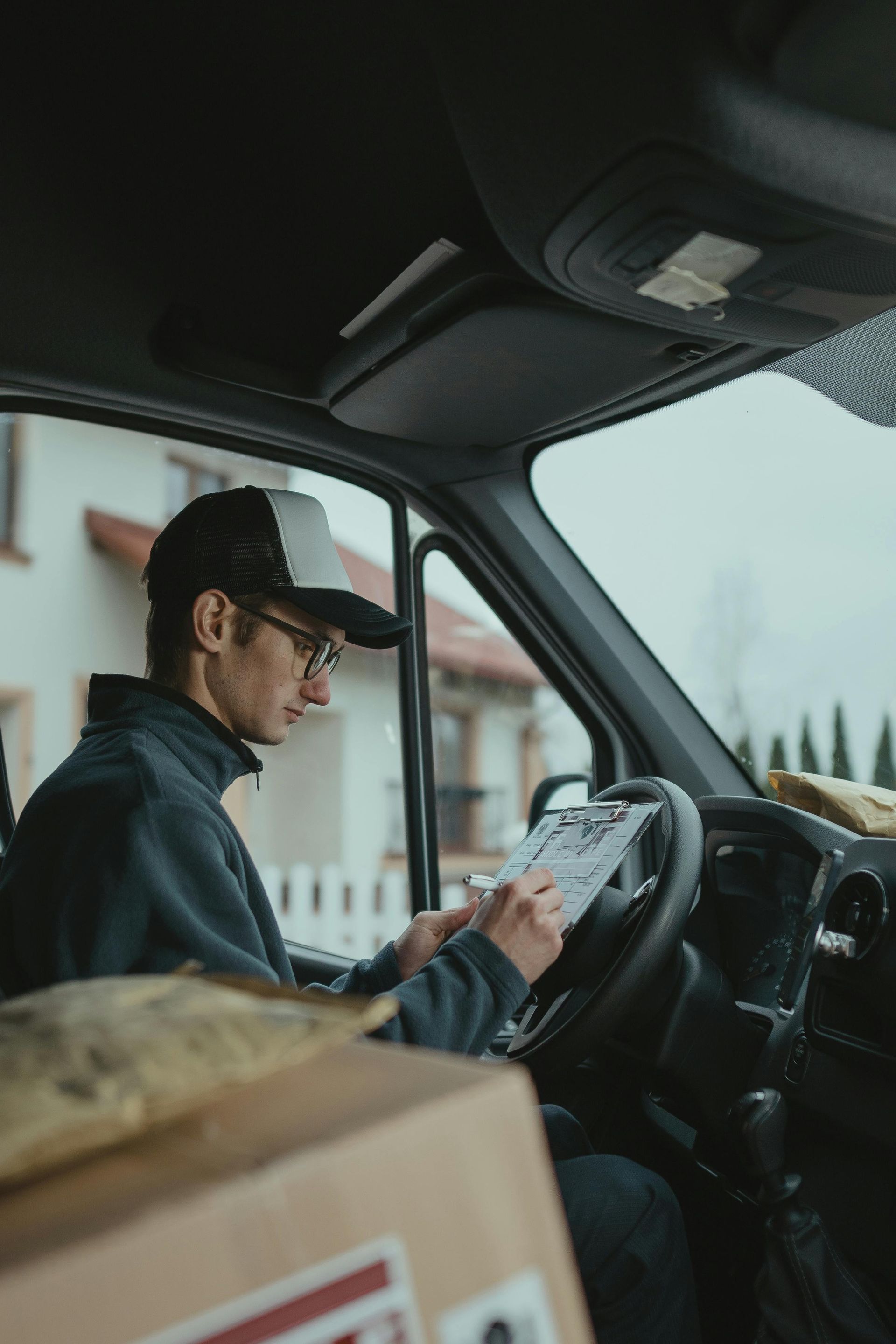 Delivery driver in Minnesota preparing packages and reviewing delivery route inside a van