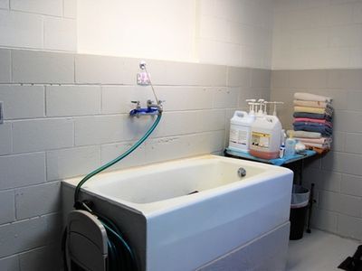 A bathroom with a bathtub and a hose attached to it.