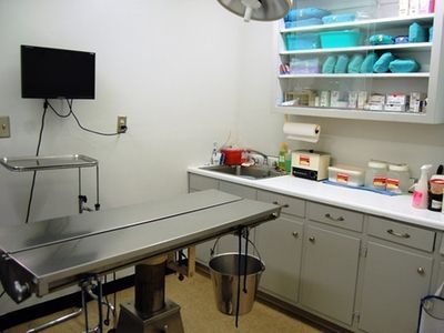 An operating room with a stainless steel table and a sink
