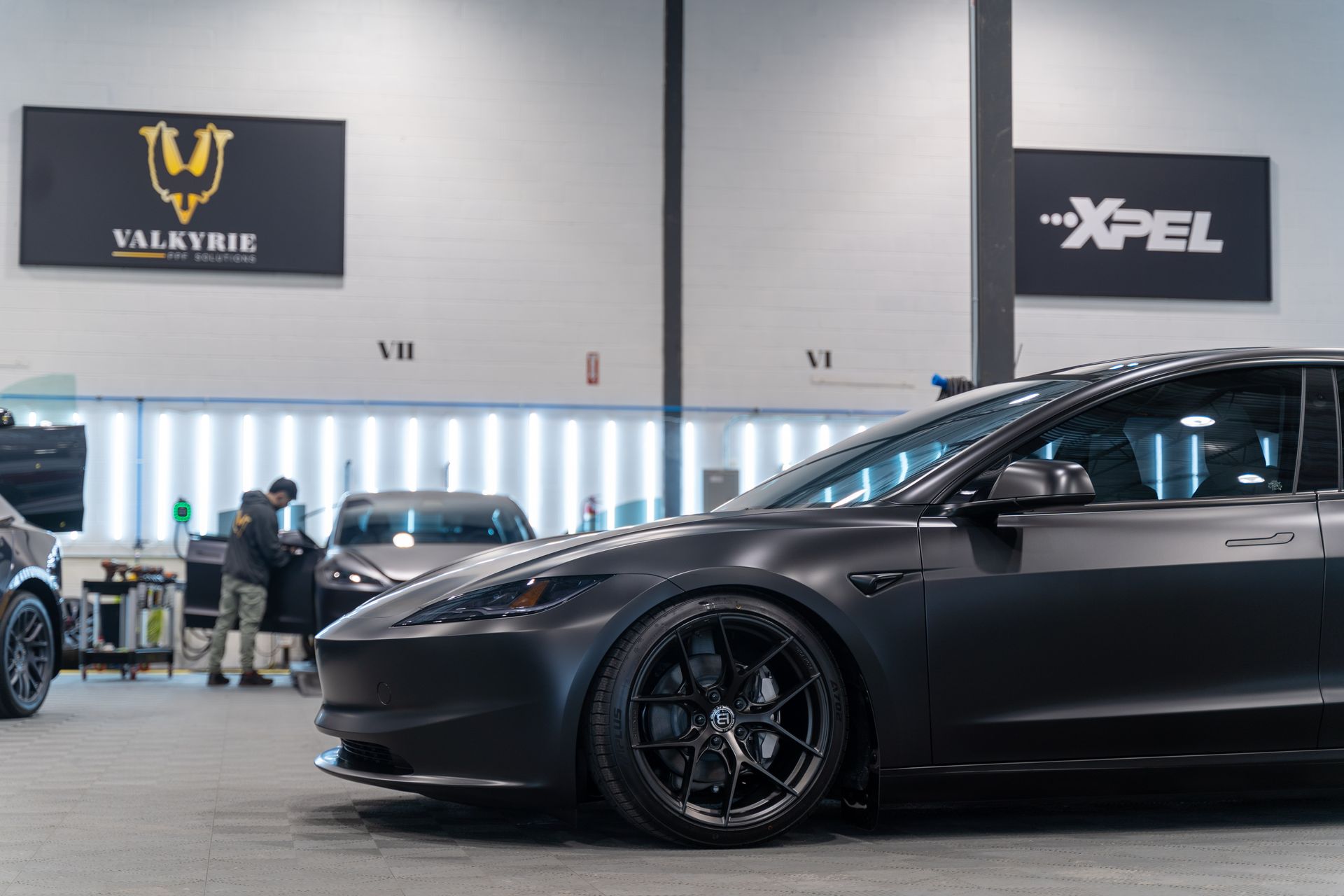 a blue Tesla Model 3 on the street