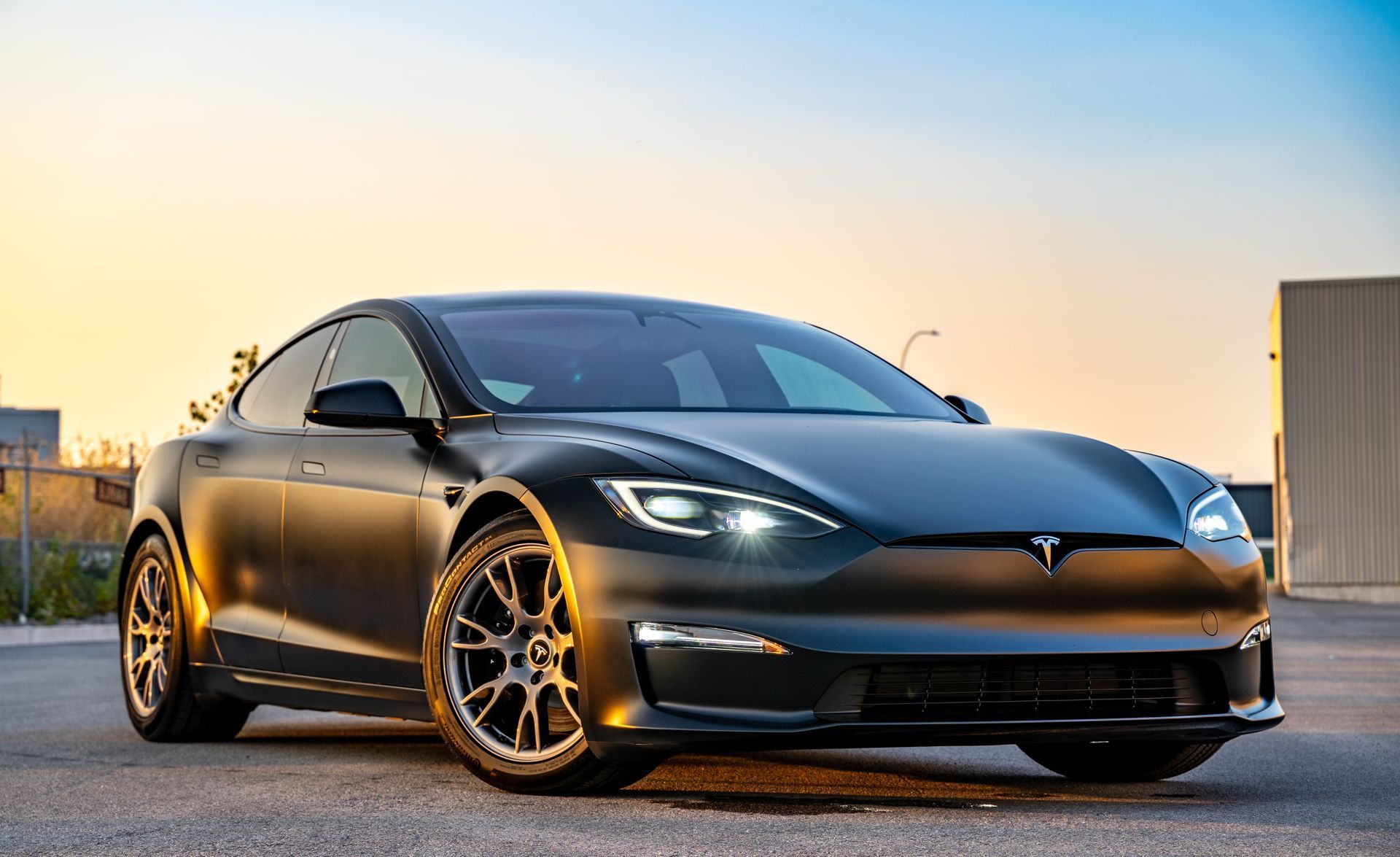 A red tesla model s is parked in a garage.