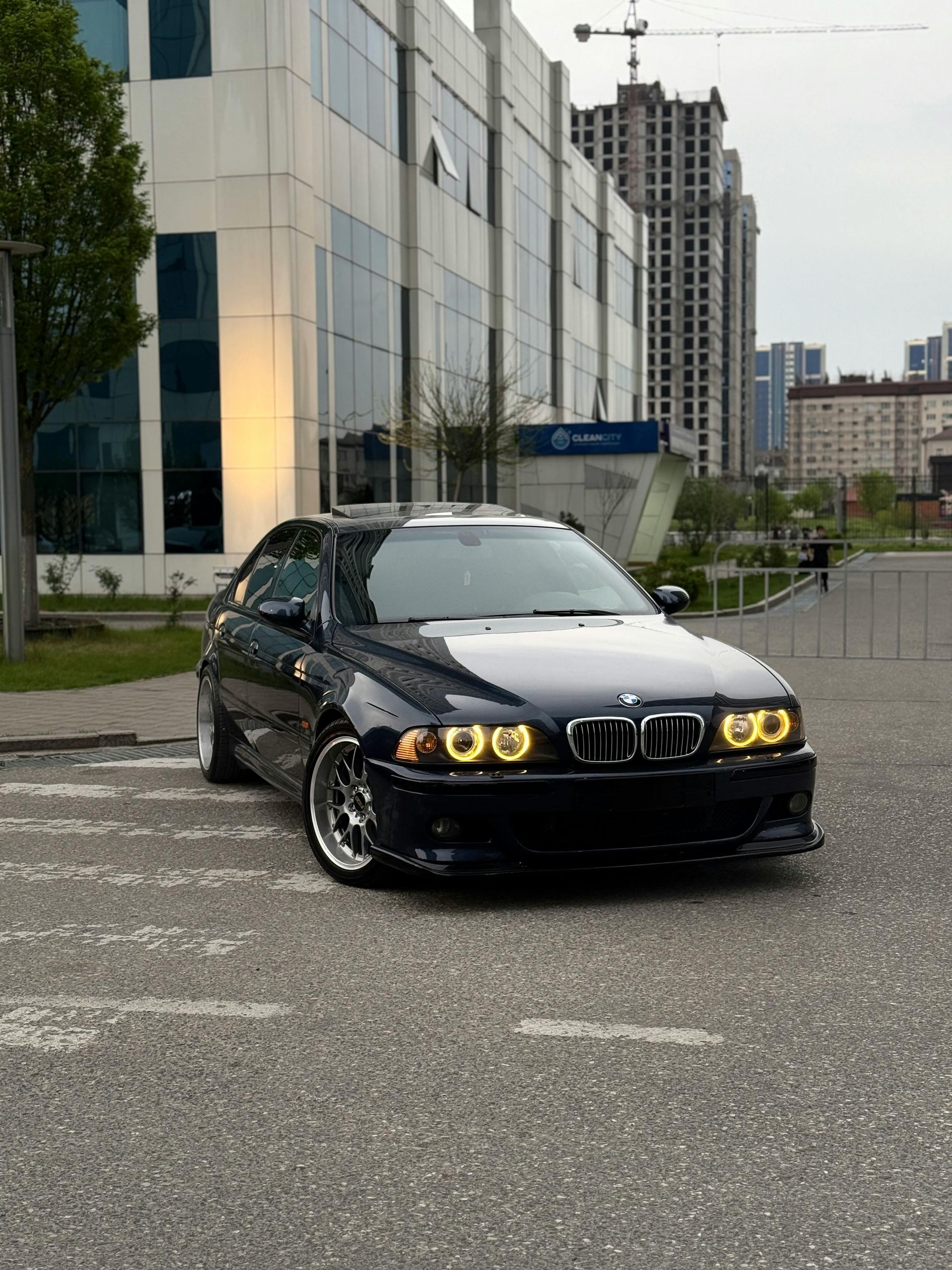 A black and white bmw is parked in front of a building