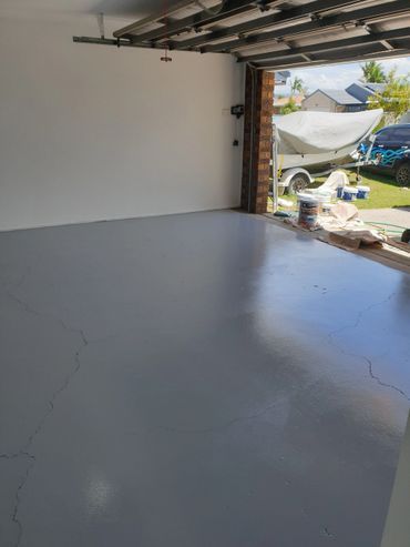 A Man is Standing on a Ladder Painting the Side of a House — Magic Wand Roof Restoration & Painting in Mermaid Beach, QLD