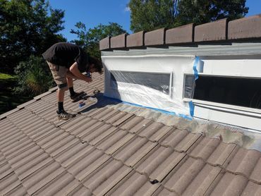 A Man is Working on a Tiled Roof — Magic Wand Roof Restoration & Painting in Mermaid Beach, QLD