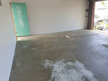 A Man is Painting the Side of a House — Magic Wand Roof Restoration & Painting in Mermaid Beach, QLD