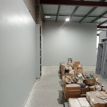 A Man is Painting a Wall — Magic Wand Roof Restoration & Painting in Mermaid Beach, QLD