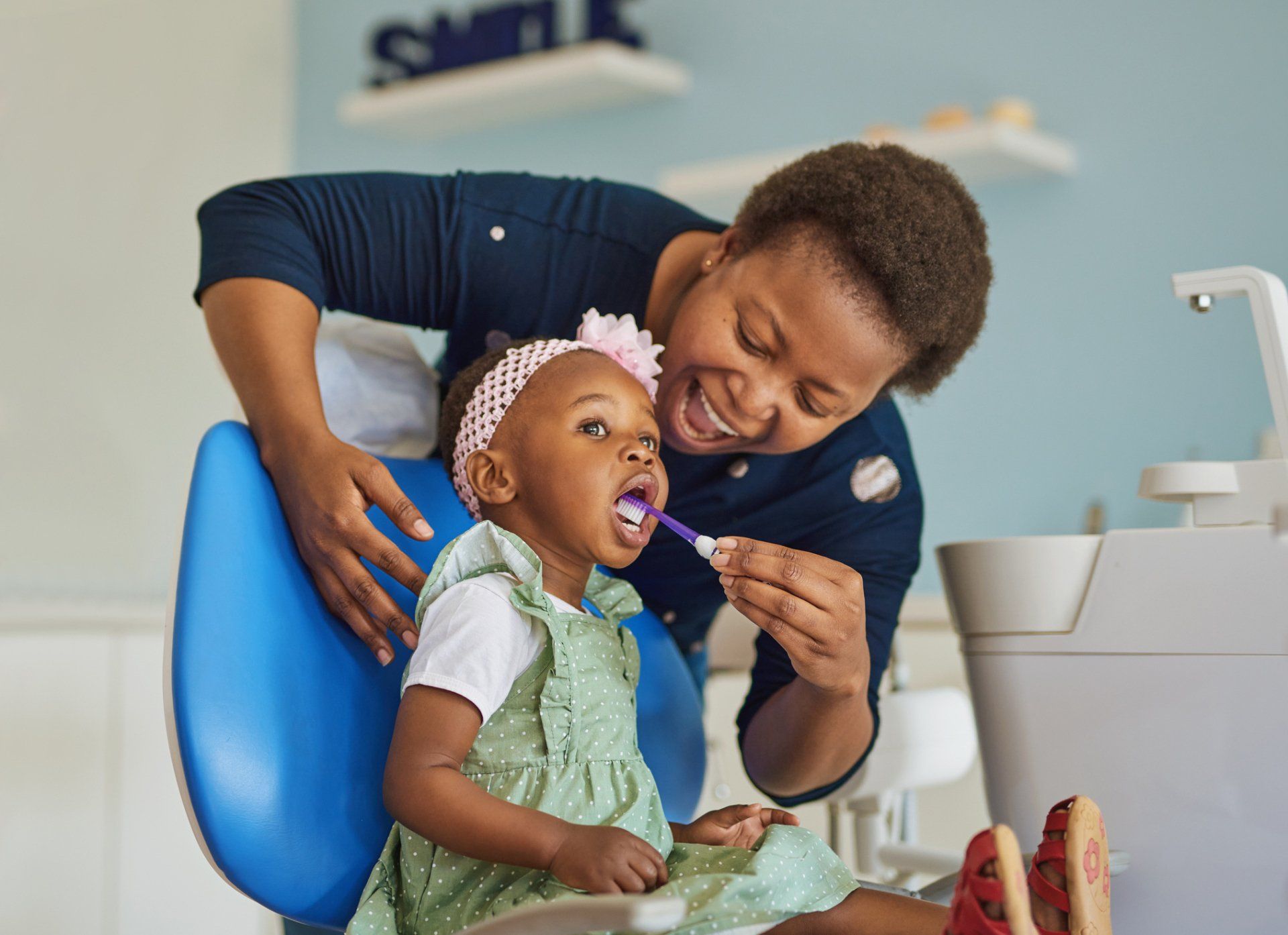Young woman brushing her adorable daughter’s teeth — Madison, WI — East Grove Dental