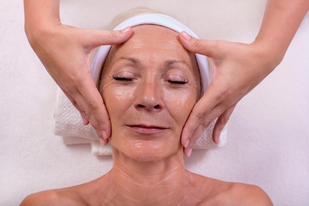 An Older Woman Is Getting A Facial Massage At A Skin Clinic — Mackay Skin Clinic In North Mackay, QLD
