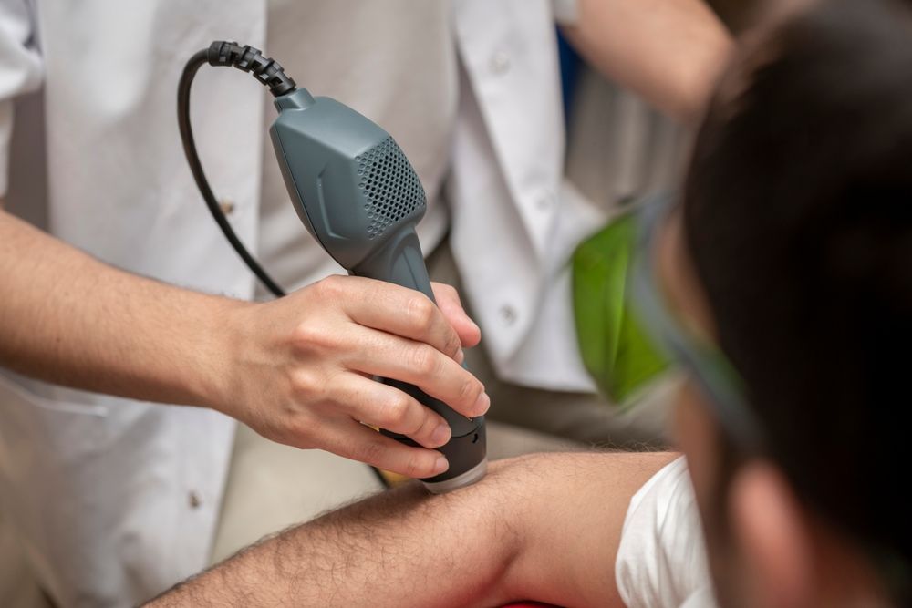 A Person Is Getting A Laser Treatment On Their Arm — Mackay Skin Clinic In North Mackay, QLD
