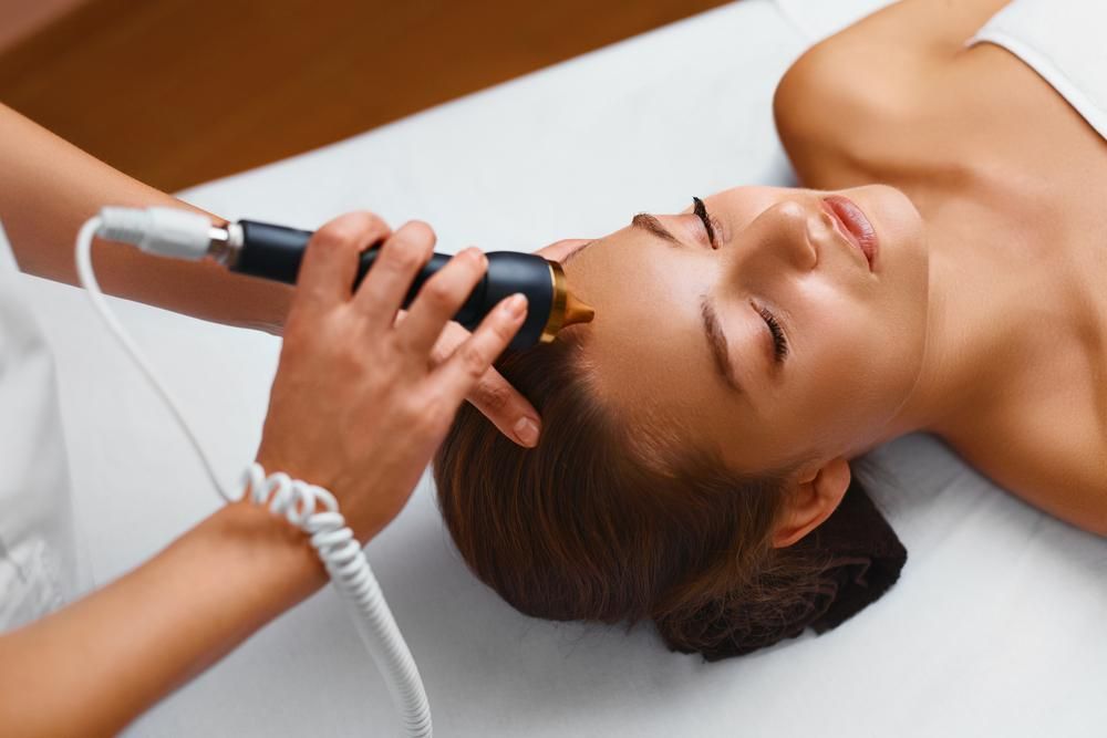A Woman Is Getting A Facial Treatment At A Skin Clinic — Mackay Skin Clinic In North Mackay, QLD
