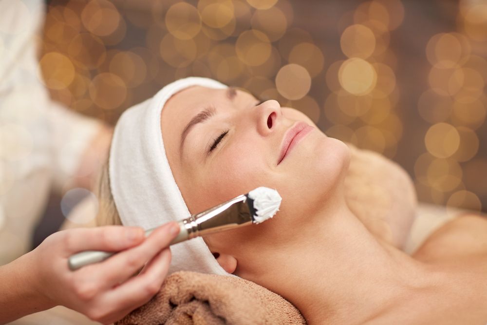 A Woman Is Getting A Facial Treatment At A Beauty Salon — Mackay Skin Clinic In North Mackay, QLD