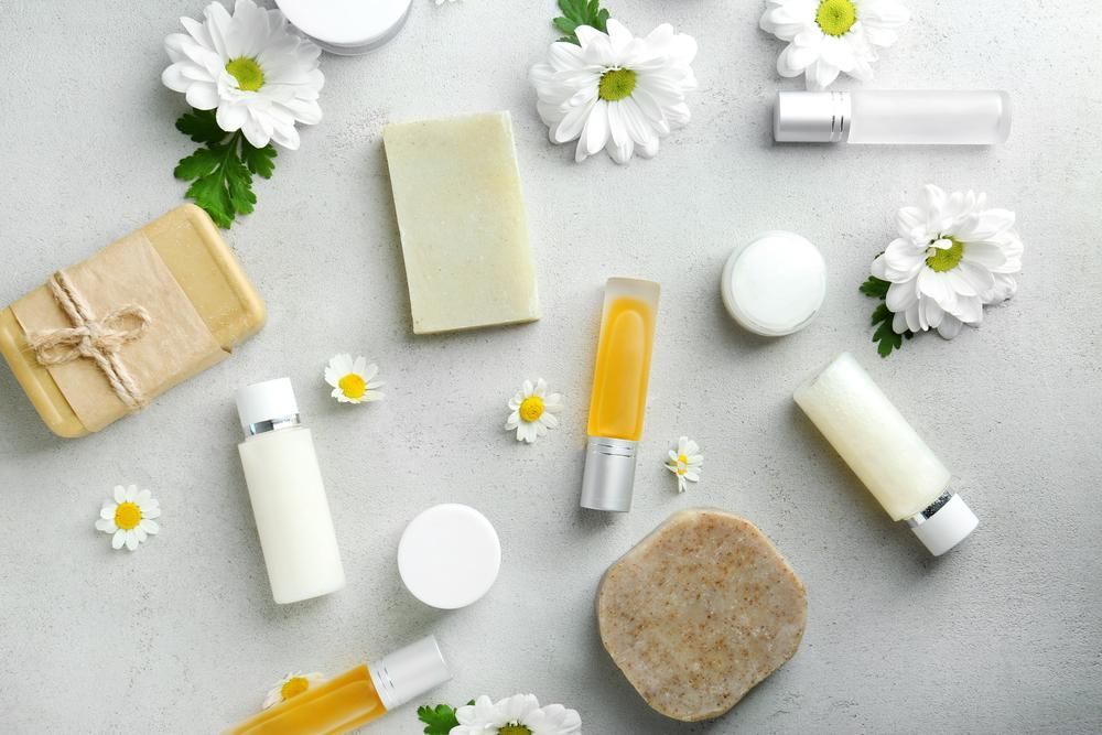 There Are Many Different Types Of Cosmetics And Flowers On The Table — Mackay Skin Clinic In North Mackay, QLD