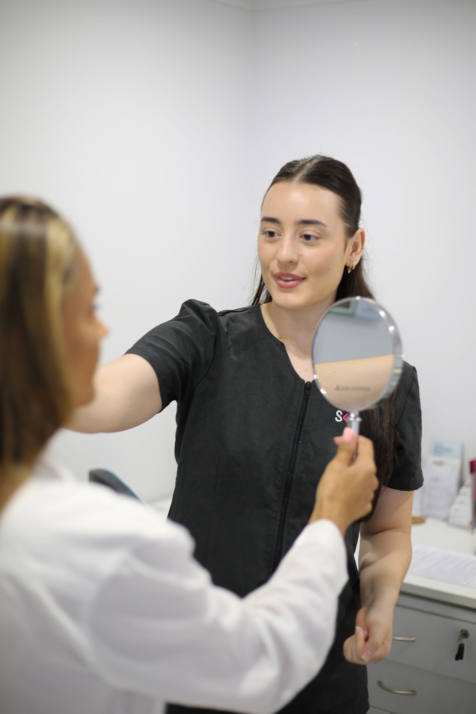 A Woman Is being treated by a Beauty Therapist In A Skin Clinic — Mackay Skin Clinic In North Mackay, QLD