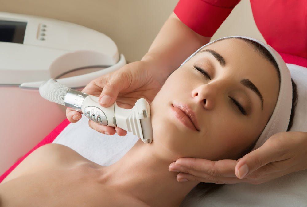 A Woman Is Getting A Facial Treatment At A Beauty Salon — Mackay Skin Clinic In North Mackay, QLD