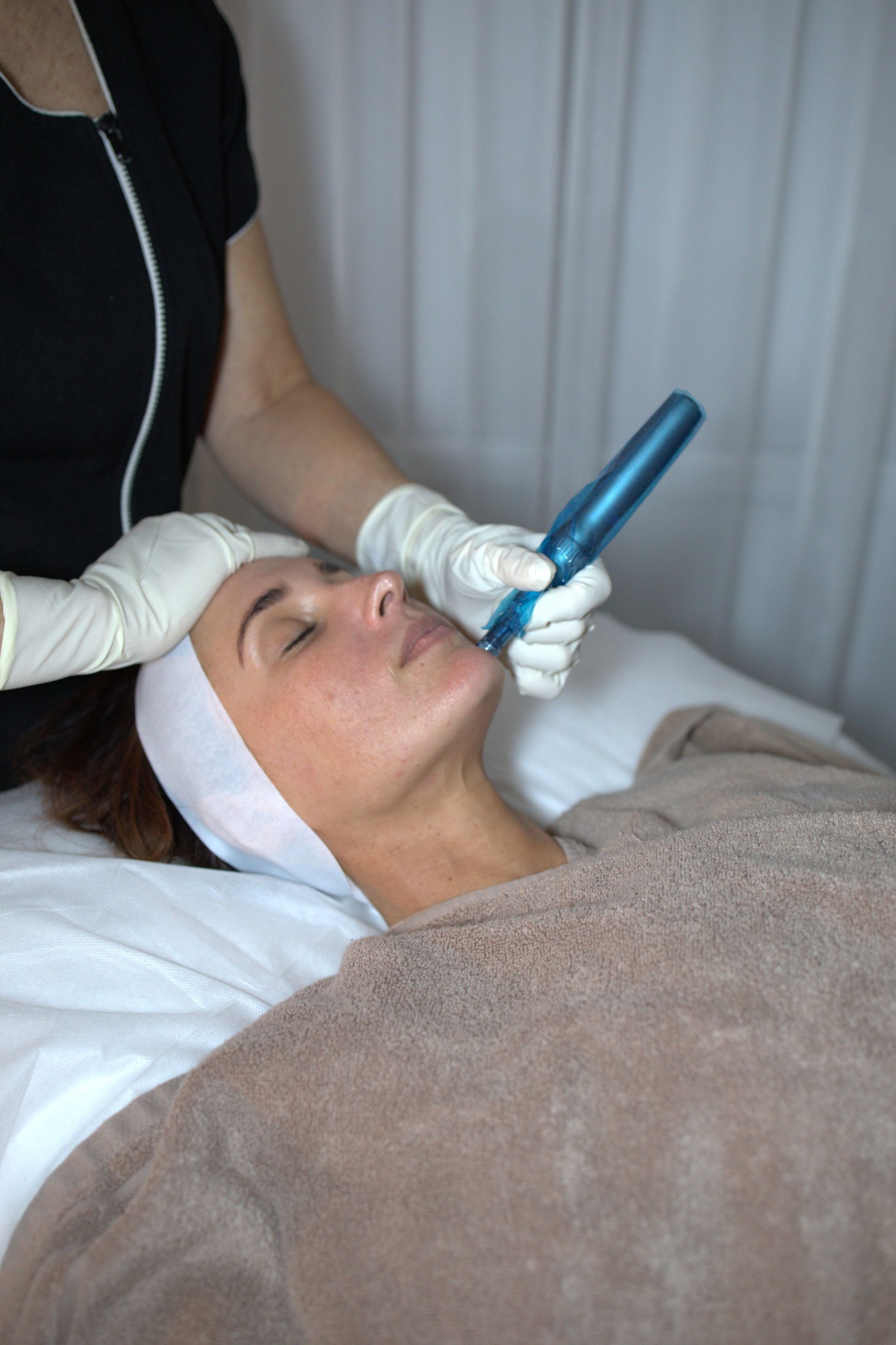 A Woman Is Getting A Facial Treatment At A Beauty Salon — Mackay Skin Clinic In North Mackay, QLD