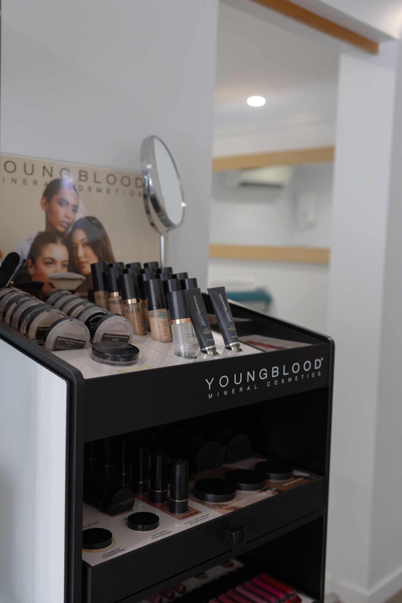 YoungBlood Mineral Cosmetics products displayed on a black stand At A Beauty Salon — Mackay Skin Clinic In North Mackay, QLD