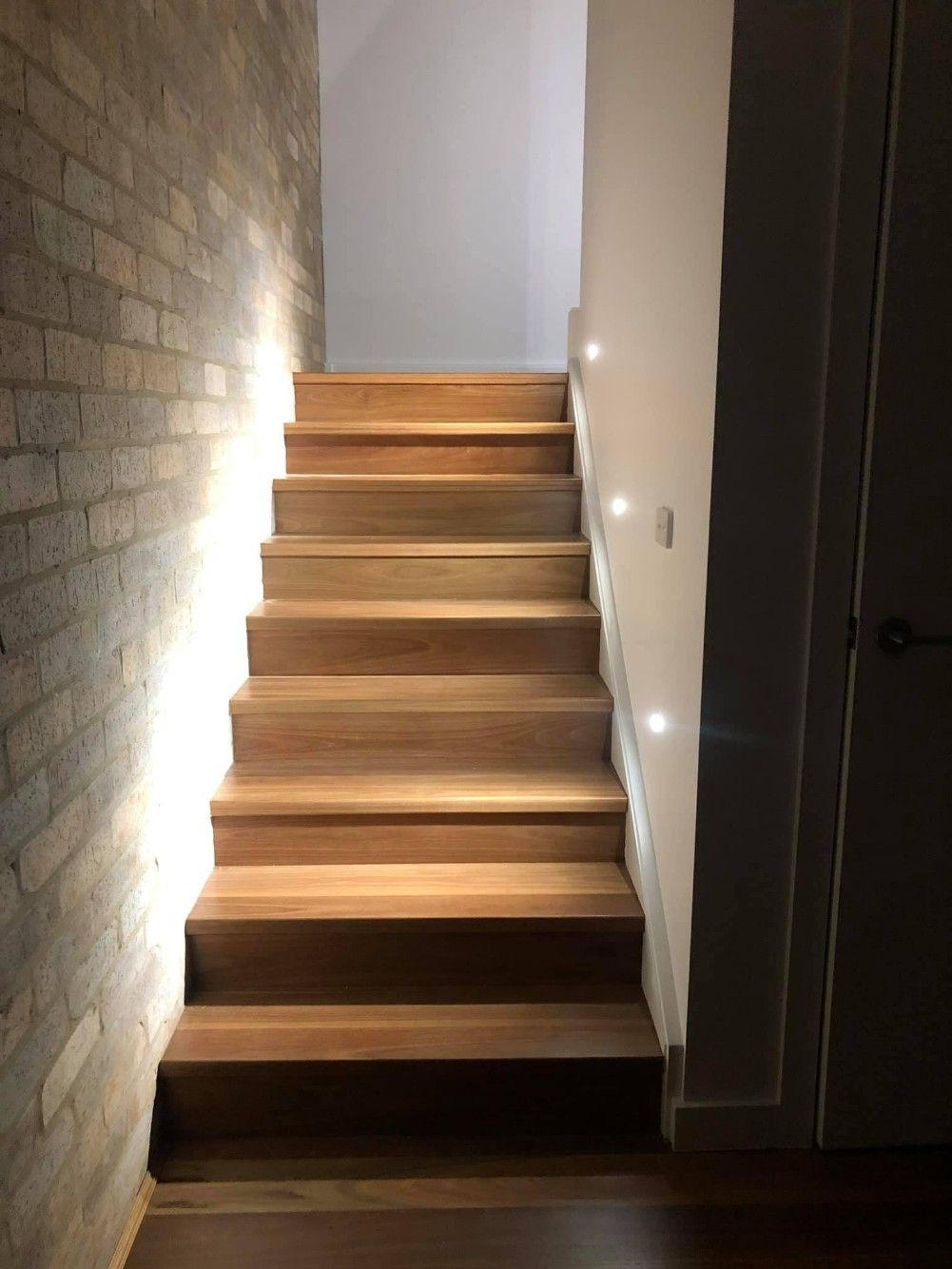 A Wooden Staircase With a Brick Wall Behind It — Imperial Build Co. in Tuggeranong, ACT