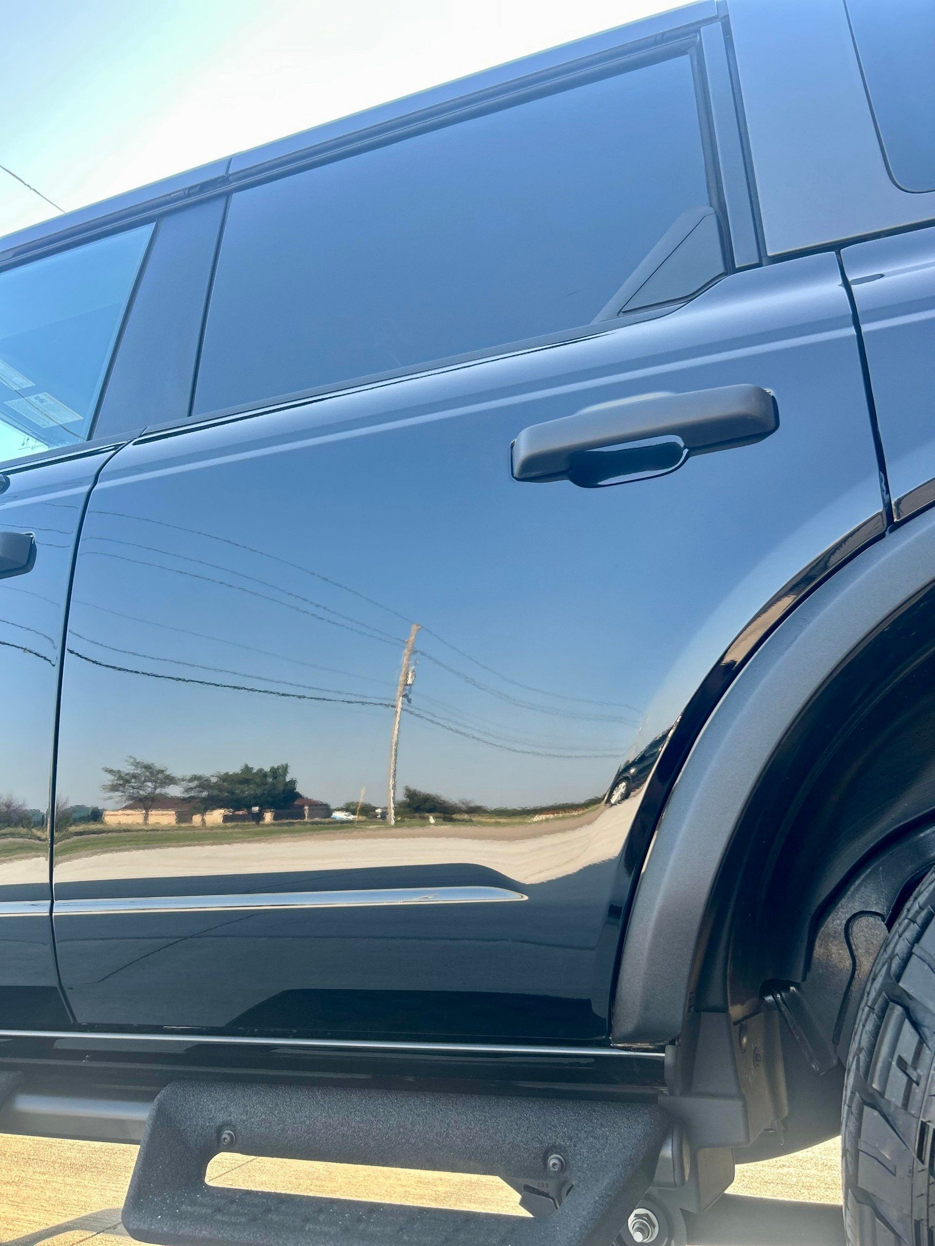 A black car is parked on the side of the road.