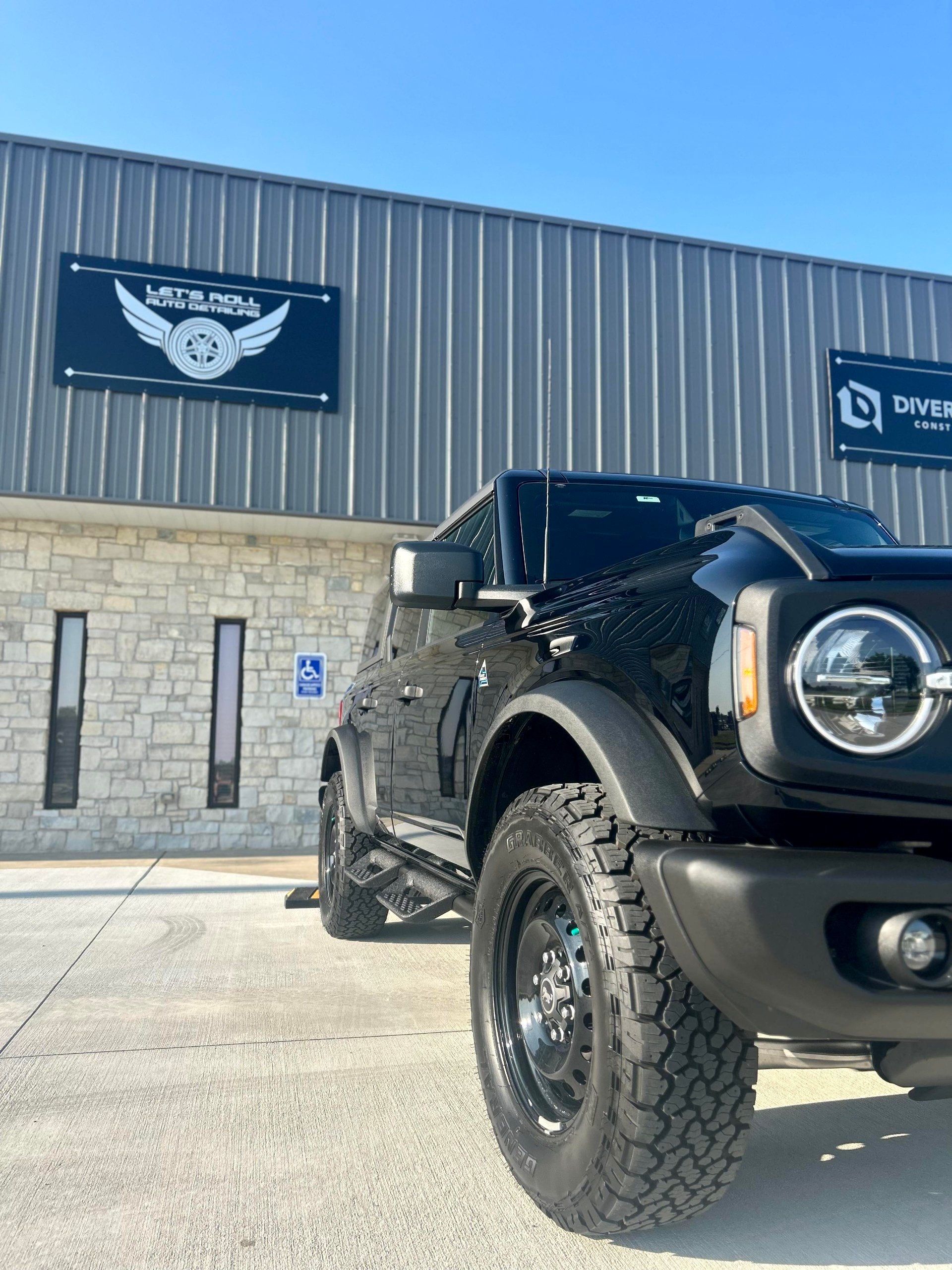 A black truck is parked in front of a building.