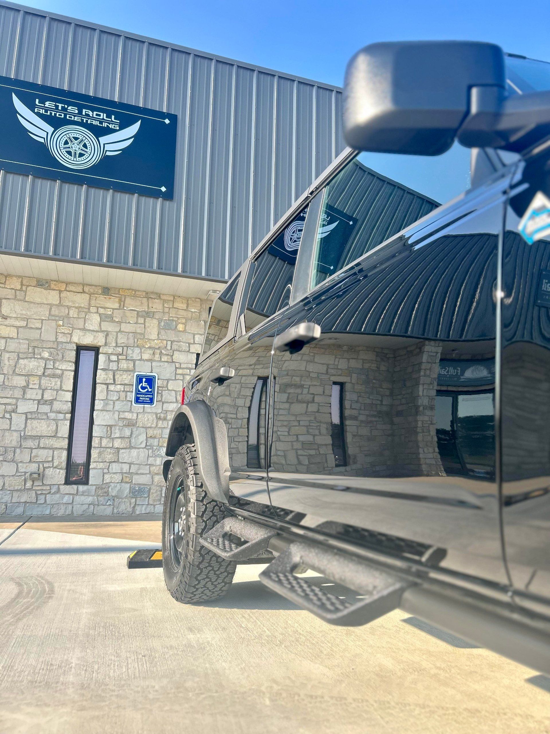 A black truck is parked in front of a brick building