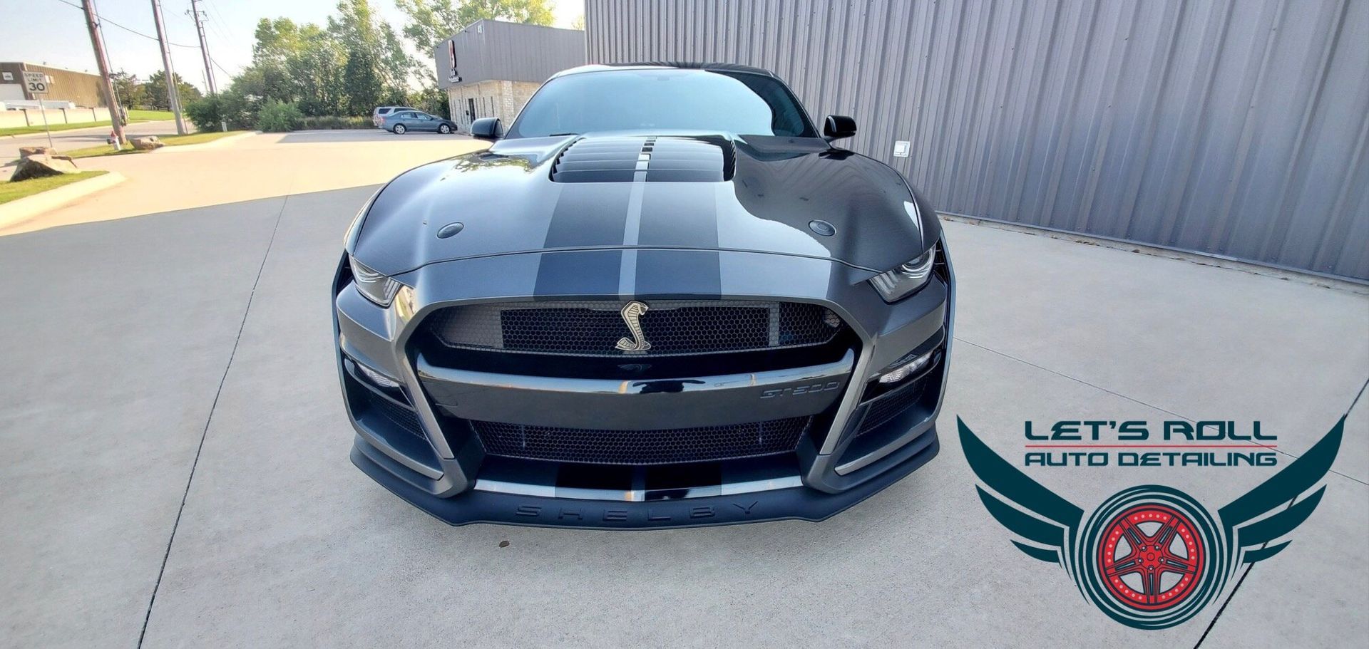 A black ford mustang is parked in front of a building.