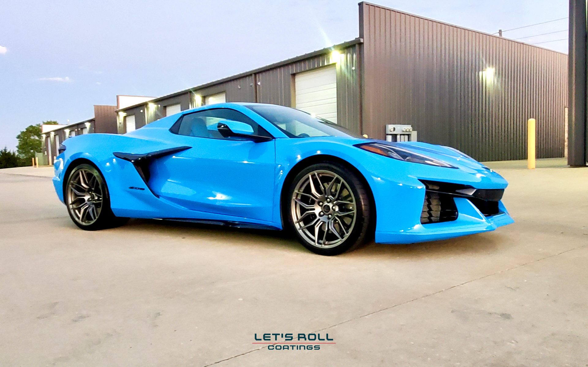 A blue sports car is parked in front of a building.