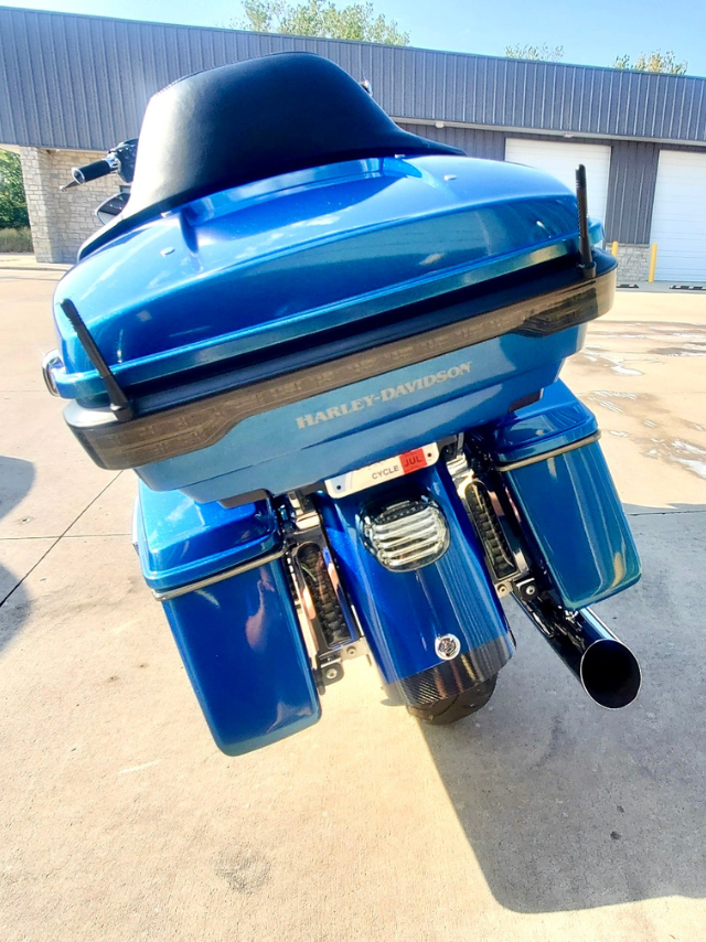 A blue harley davidson motorcycle is parked in front of a building