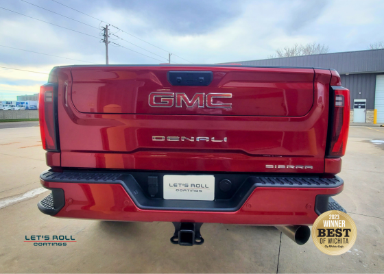 A red gmc denali truck is parked in a parking lot
