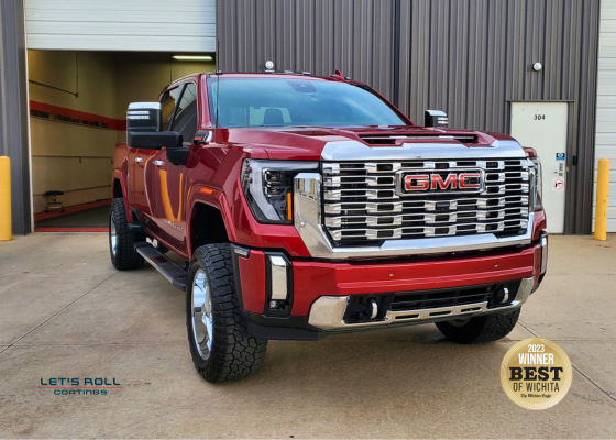 A red gmc truck is parked in front of a building