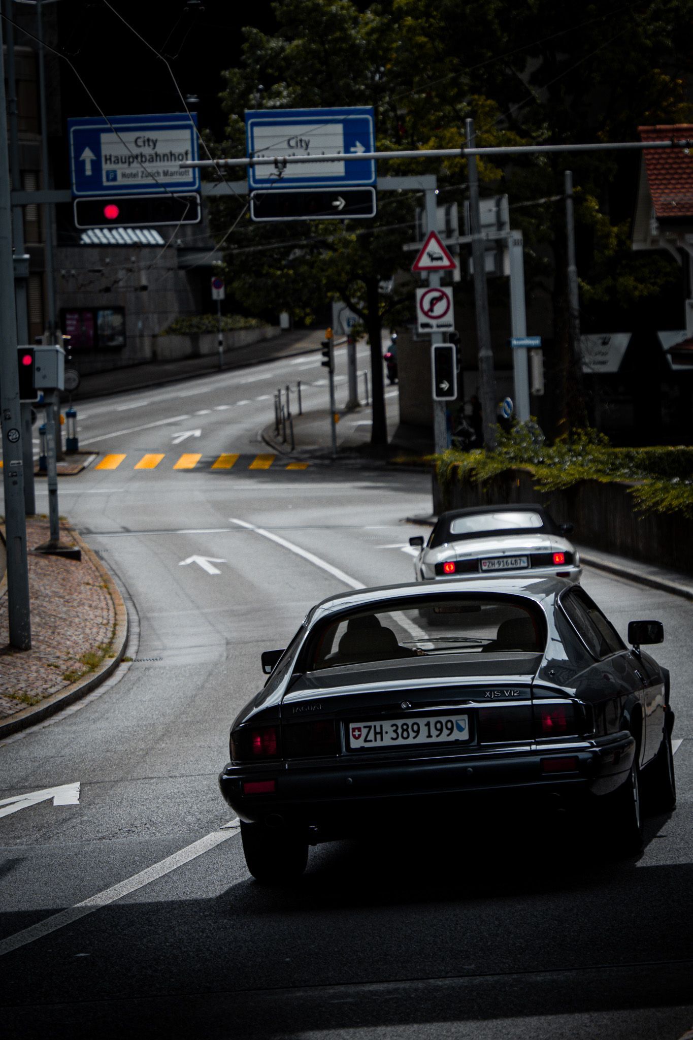 Een zwarte auto rijdt door een stadsstraat.