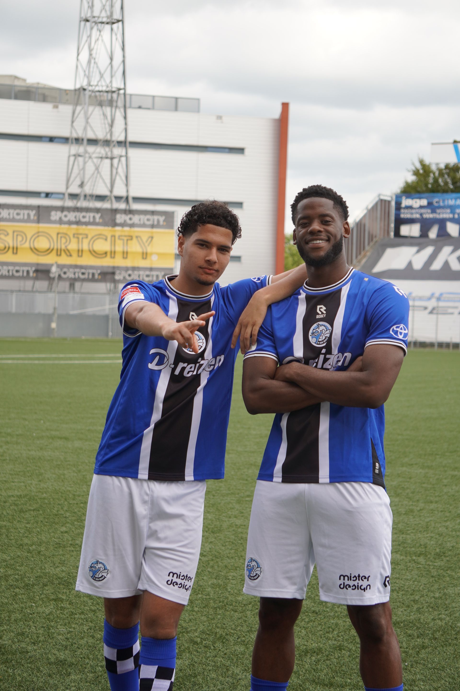 Twee voetballers staan ​​naast elkaar op een veld.