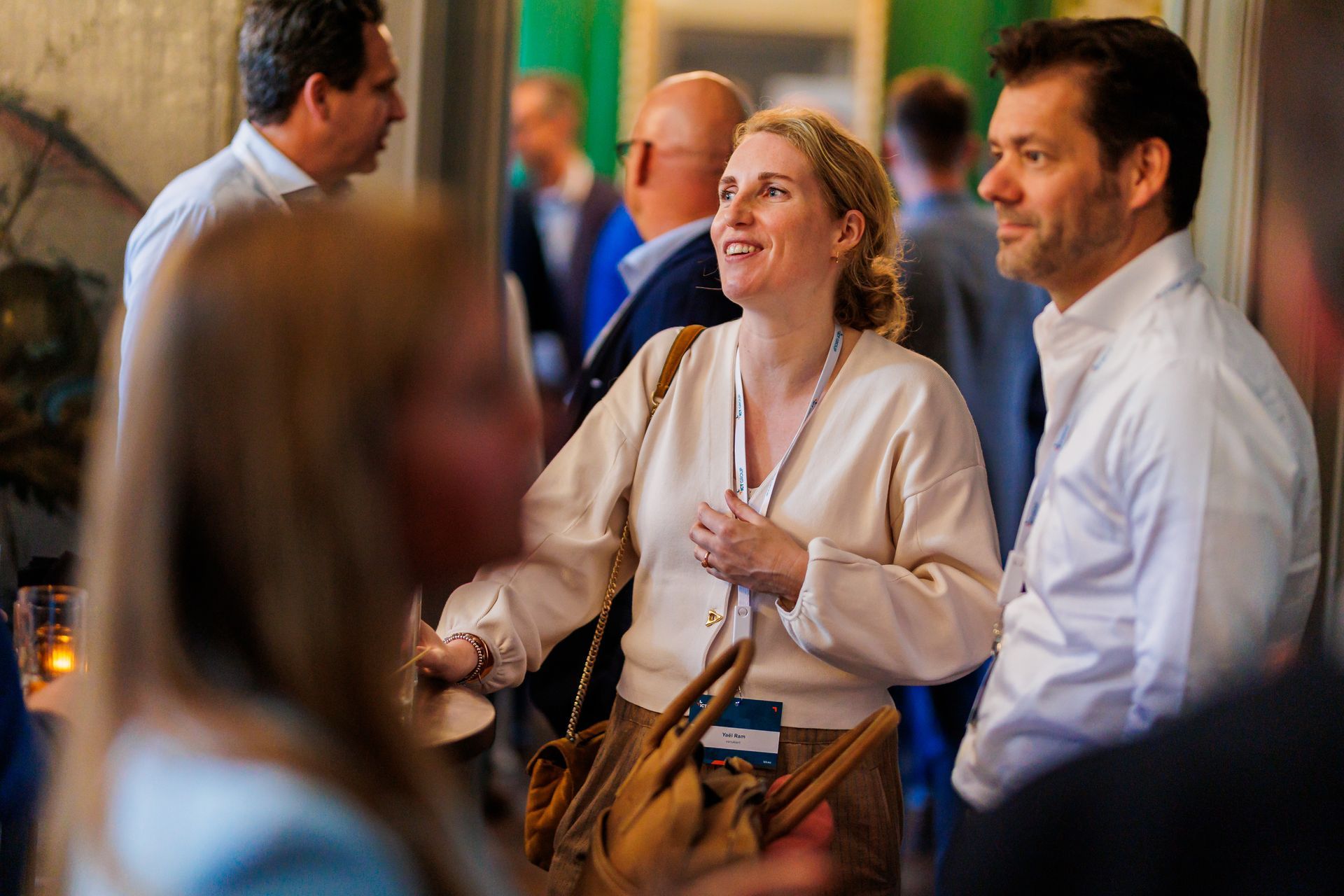 Een groep mensen staat in een kamer en praat met elkaar.