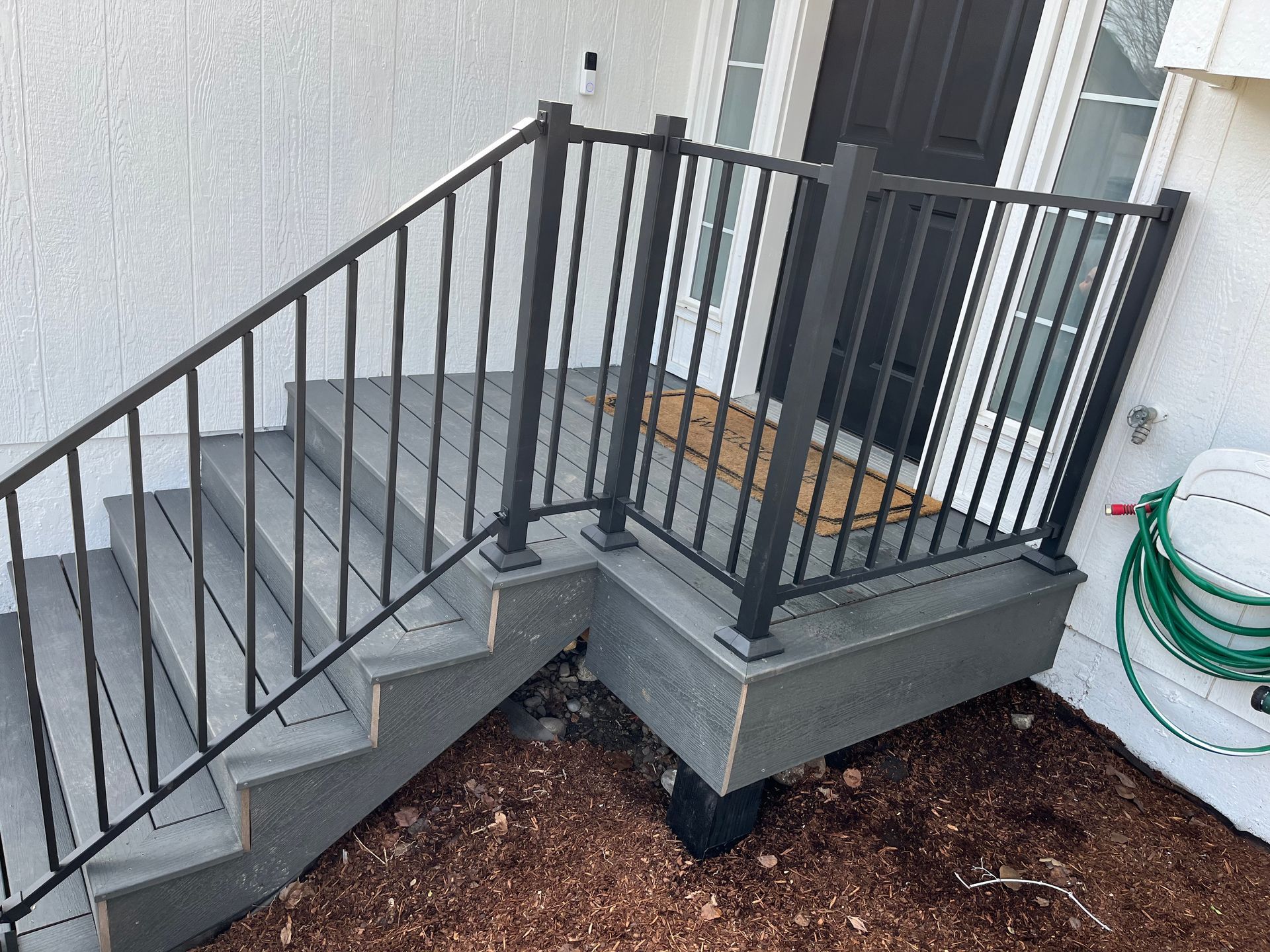 A Set of Stairs With a Metal Railing Leading Up to a Door