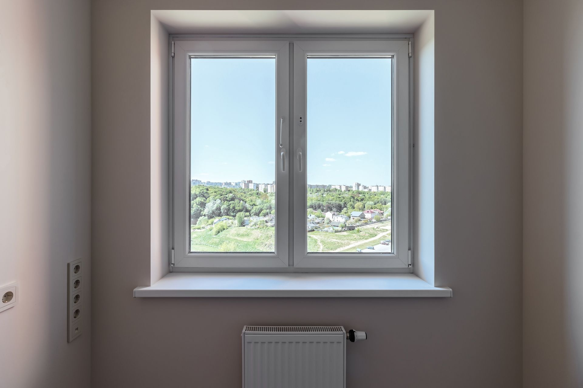 An Empty Room With a Window and a Radiator