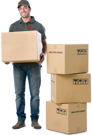 Delivery person holding a large box, standing next to a stack of boxes.
