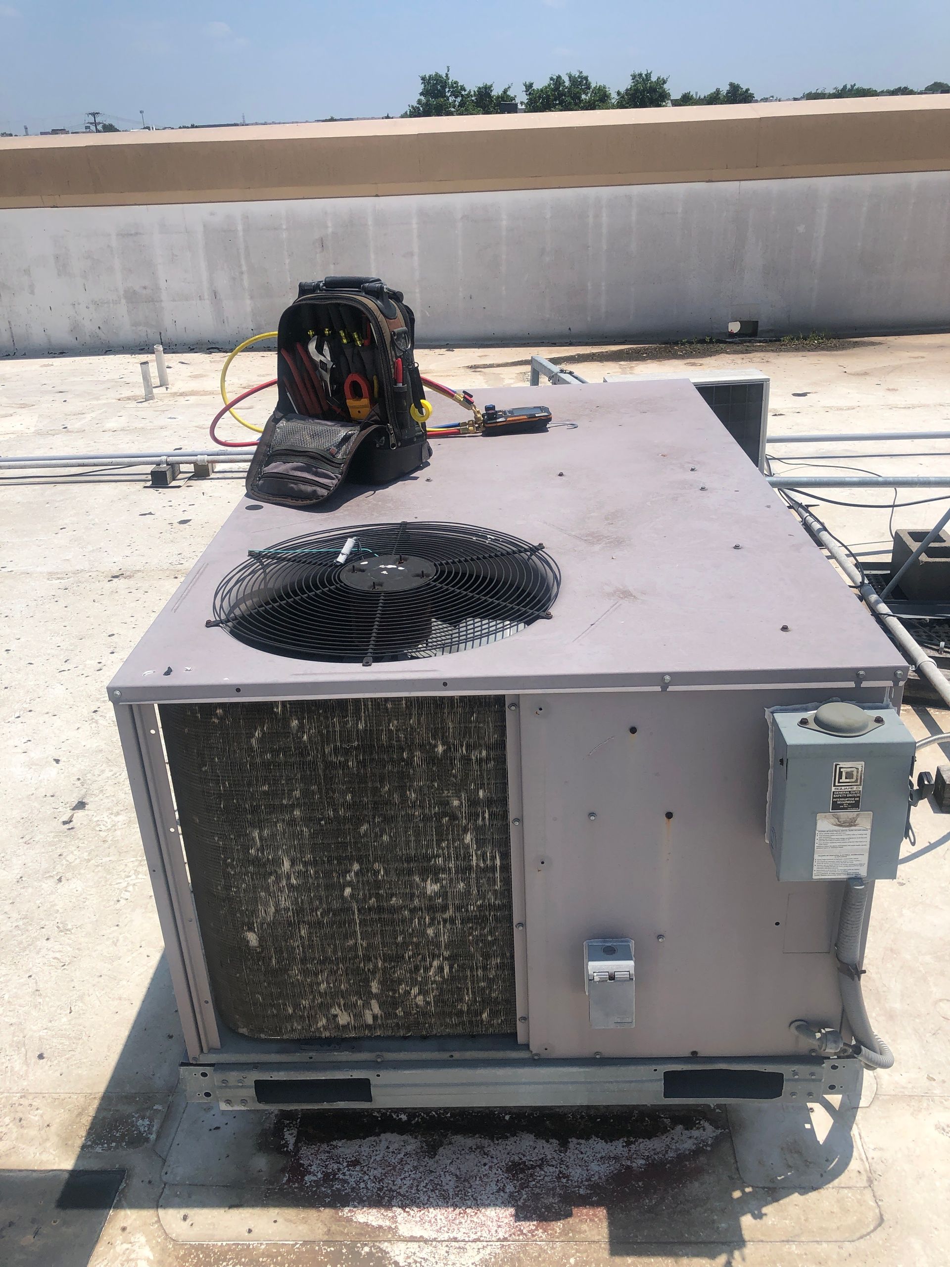 A large air conditioner is sitting on top of a roof.