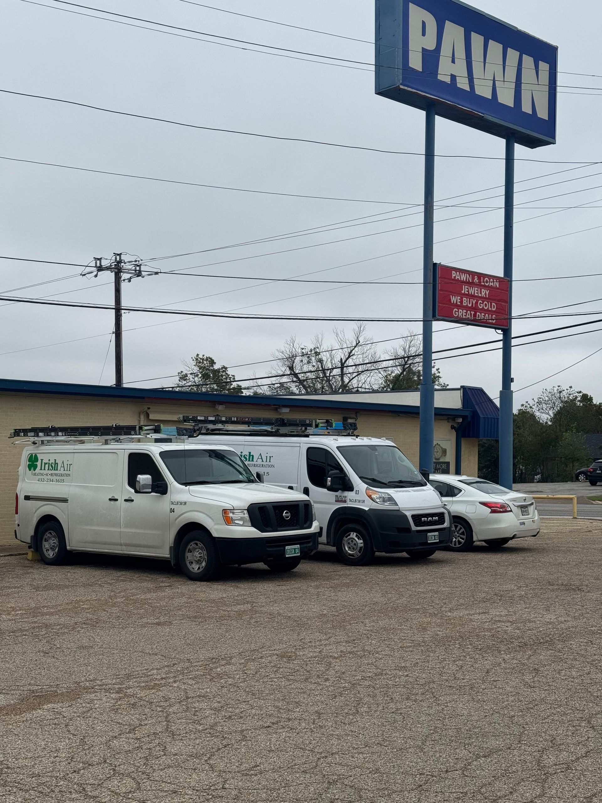 Three vans are parked in front of a pawn shop