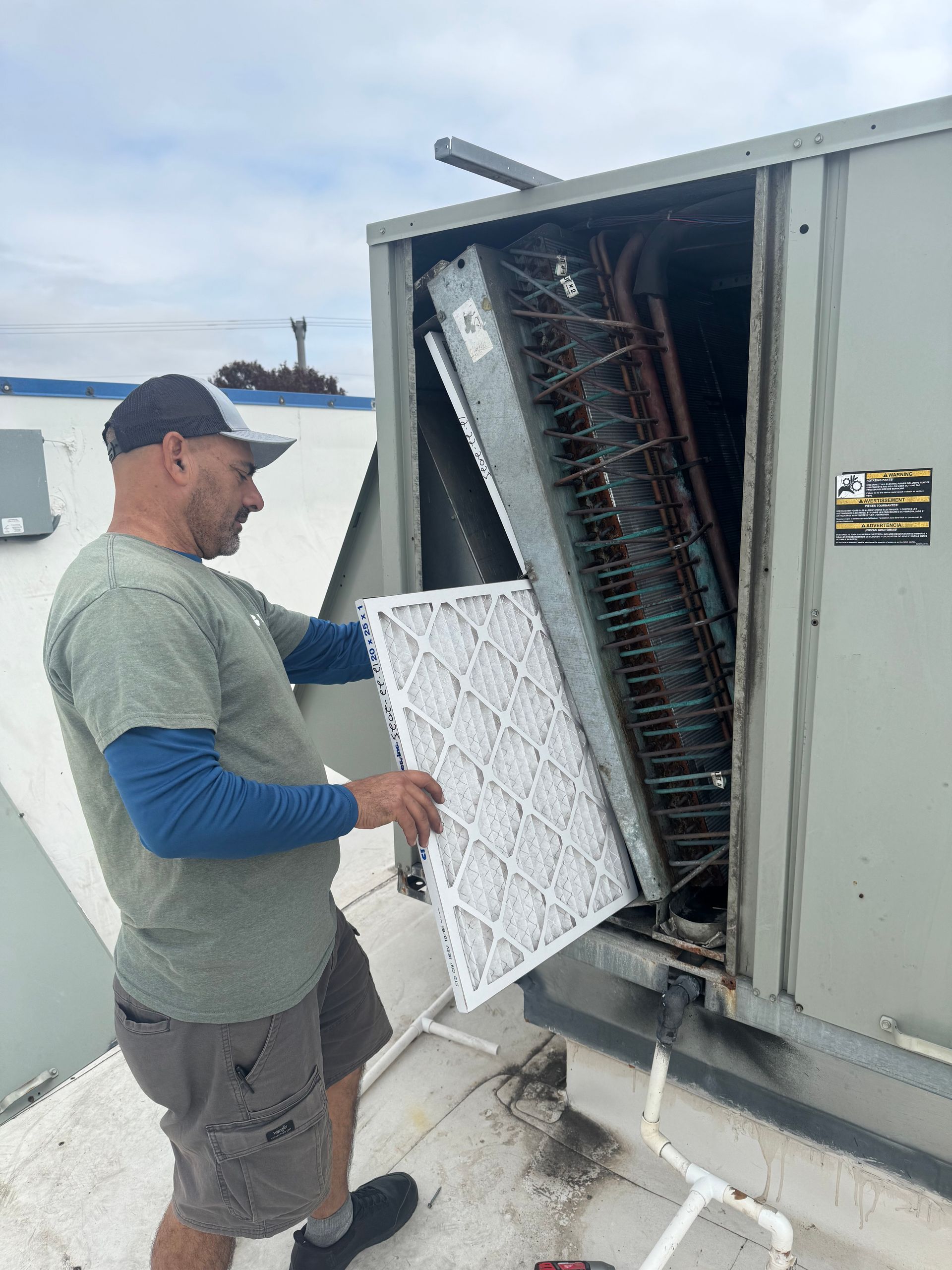 An air conditioner is being lifted by a crane in the sky