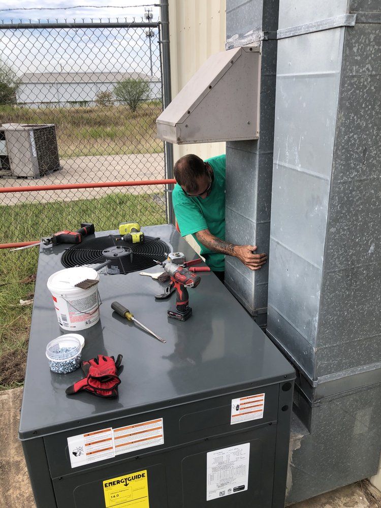 A man is working on an air conditioner outside of a building.