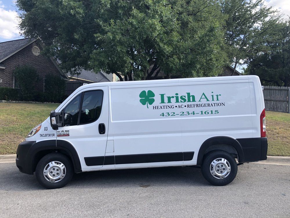 A white van with irish air written on the side is parked on the side of the road.