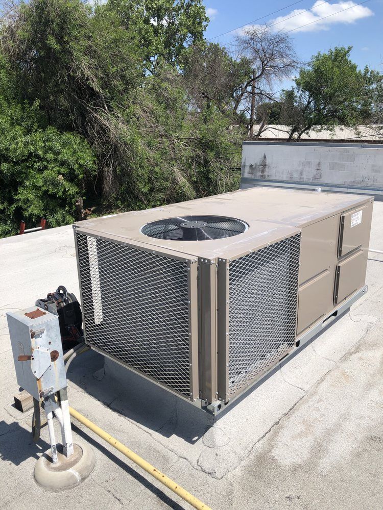 A large air conditioner is sitting on top of a roof.