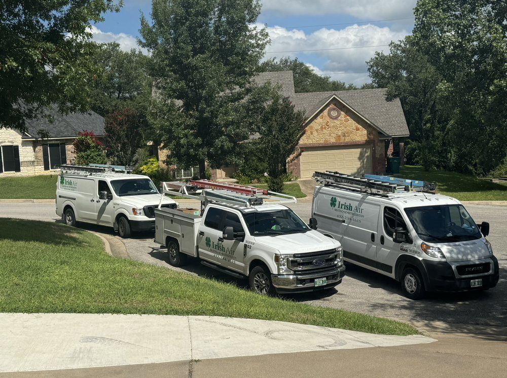 Three trucks are parked on the side of the road in front of a house.