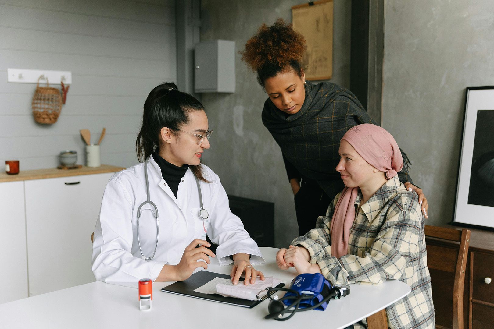 A doctor is talking to a child with cancer while a woman looks on.